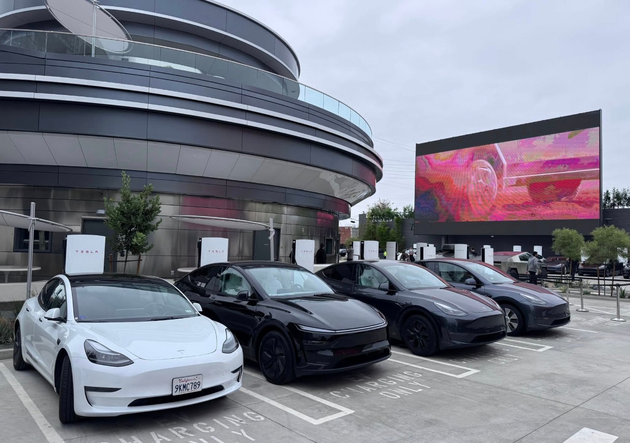 Voitures électriques en charge devant un bâtiment moderne.