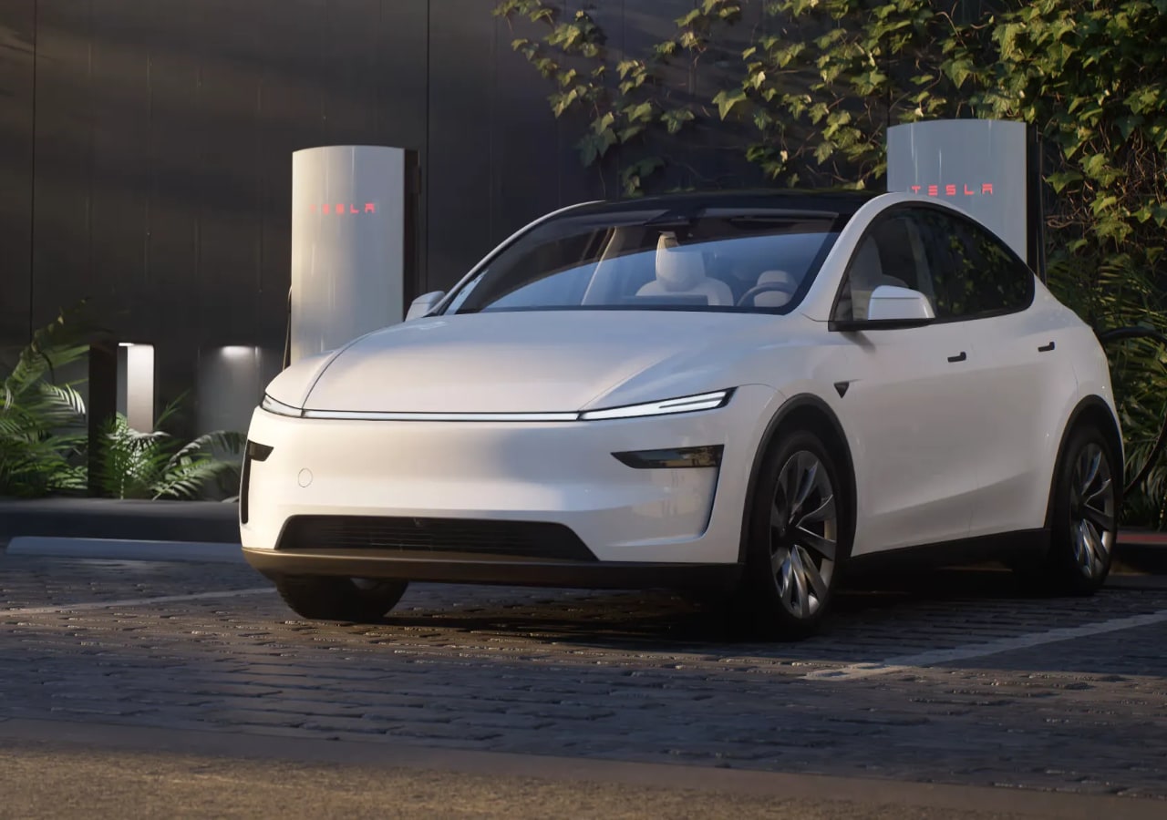 Voiture électrique blanche garée devant une borne Tesla.